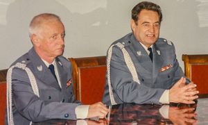 dwóch policjantów siedzi przy stole.