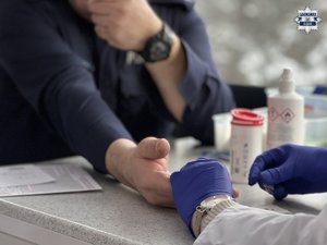 mężczyzna w stacji krwiodawstwa. Opatrunek na ręku.