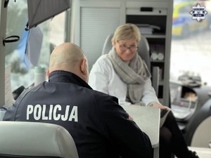 Policjant oddaje krew. Plaster na ręku.
