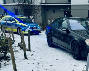 Radiowóz policyjny stoi za samochodem, którym jechał zatrzymany 44-latek.