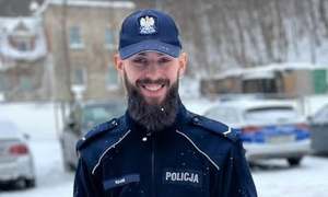 Policjant stoi uśmiecha się.