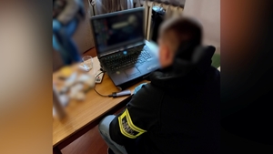 Policjant CBCZ przed komputerem.