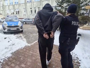 Policjantka prowadzi zatrzymanego.