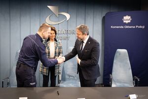 Komendant Główny Policji podaje rękę mężczyźnie z Totalizatora Sportowego.