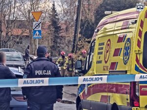 Karetka pogotowia i służby ratunkowe stoją przy ulicy.