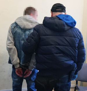 Policjanci prowadzą zatrzymanych.