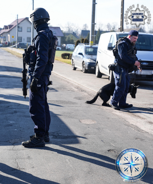 uzbrojony policjant i policjant  z psem.