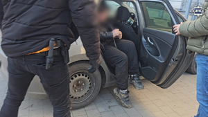 Policjanci prowadzą zatrzymanego.