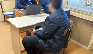 Zatrzymany siedzi przed policjantem.