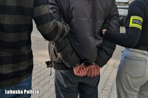 Policjanci prowadzą zatrzymanego.