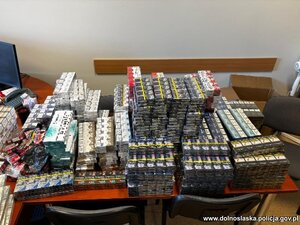 na podłodze rozłożone są kartony i worki z nielegalnym tytoniem, papierosami i odzieżą.