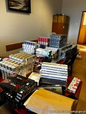 na podłodze rozłożone są kartony i worki z nielegalnym tytoniem, papierosami i odzieżą.