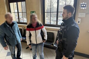 policjant prowadzi kobietę.