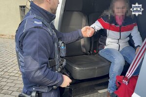 policjant prowadzi kobietę.