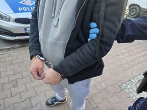 policja prowadzi zatrzymanego.