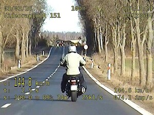Stopklatka z nagrania wideorejestratora przedstawia pojazd jadący drogą przekraczający prędkość.