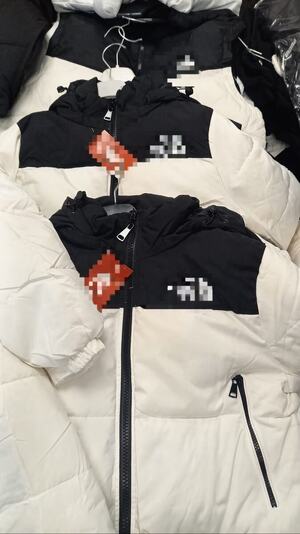 bluzki, kurtki, czapki i torby porozkładane na podłodze i w kartonach.