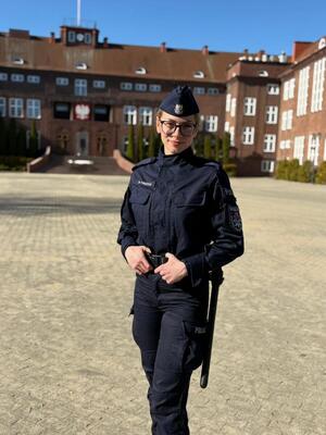Policjantka stoi na placu przed Szkołą Policji w Słupsku.