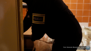 Pochylony policjant na miejscu, w którym zabezpieczono m.in. narkotyki.