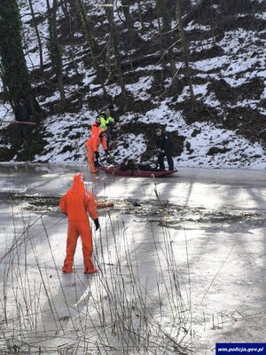 asp. szt. Paweł Kutryb oraz czterej inni mężczyźni podczas ratowania mężczyzny, który wpadł do rzeki.