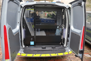 Zdjęcie przedstawia przestrzeń do przewozu osób zatrzymanych w samochodzie typu kombivan.