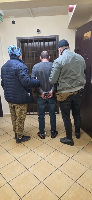 Dwaj policjanci z zatrzymanym.