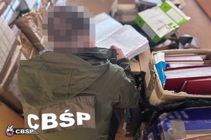 Funkcjonariusz zabezpiecza dokumenty.