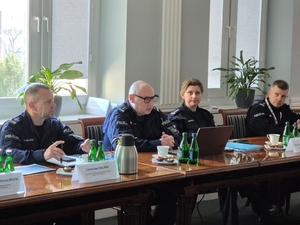 Uczestnicy polsko-litewskiego spotkania w KGP siedzą przy stole. Uczestnicy polsko-litewskiego spotkania w KGP siedzą przy stole.