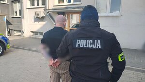 Policjant z zatrzymanym mężczyzną.