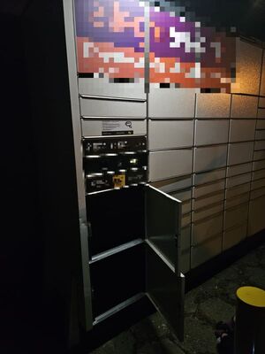 Paczkomat z otwartymi dolnymi skrytkami.