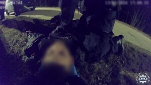 Policjnant podczas udzielania pomocy mężczyźnie leżącemu na ziemi.