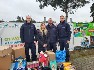 Trzej policjanci i kobieta z darami dla schroniska dla zwierząt.