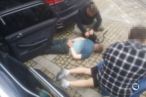 Zatrzymani leżą na ziemi.