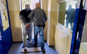 Policjanci prowadzą zatrzymanego.