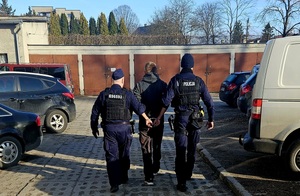 Policjanci prowadzą zatrzymanego.