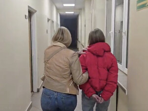 Policjantka prowadzi podejrzaną.