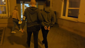 Policjantka prowadzi podejrzaną. Wchodzą do budynkukomisariatu