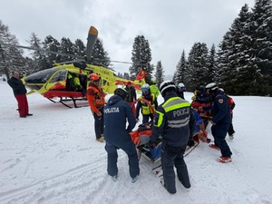 policjanci i ratownicy zabezpieczają poszkodowanego przez lotem śmigłowcem.
