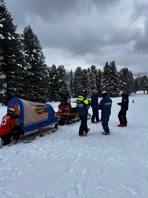Policjanci i ratownicy zabezpieczają osobę poszkodowaną w akii do transportu.