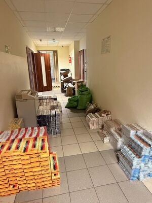 Zabezpieczone nielegalne papierosy ułożone na korytarzu.