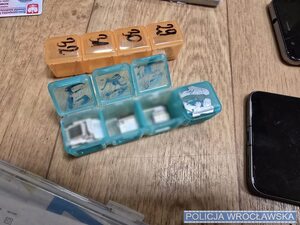 na stole porozkładane karty sim, telefony, w reklamówkach, widać telefony i pieniądze.