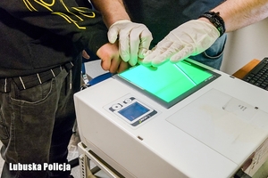 Policja zbiera odciski palców, Prowadzą zatrzymanego.