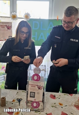 policjant i policjantka wrzucają pieniądze do puszki ze zbiórką na dziewczynkę.