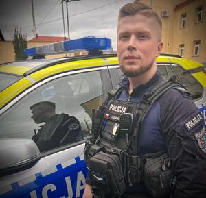 Dzielnicowy przy radiowozie.