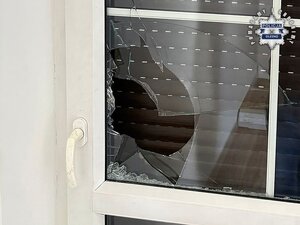 Policja prowadzi zatrzymanego. Wybita szyba, instalacja elektryczna.