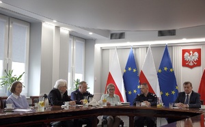 zebrani siedzą przy stole.