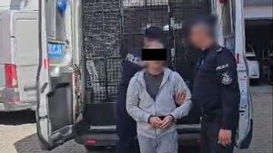 Policjanci prowadzą zatrzyamanego.