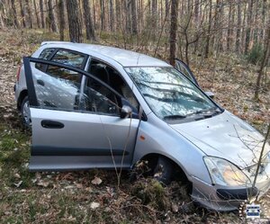 prawy bok zepsutego samochodu stojącego w lesie.