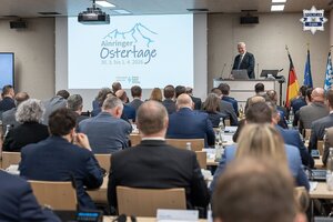 Zebrani na sali uczestnicy konferencji, a przed nimi osoba referująca.