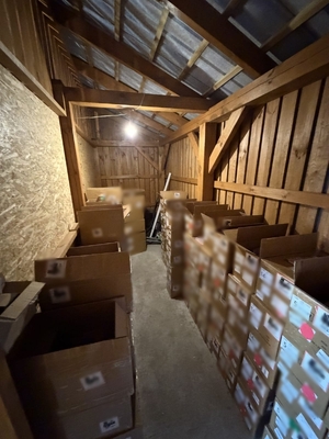 paczki i kartony leżą na strychu.  Niektóre są zafoliowane.